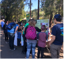 Groups of families visit our Flowers and Pollinators table on Earth Day at the Oakland Zoo.